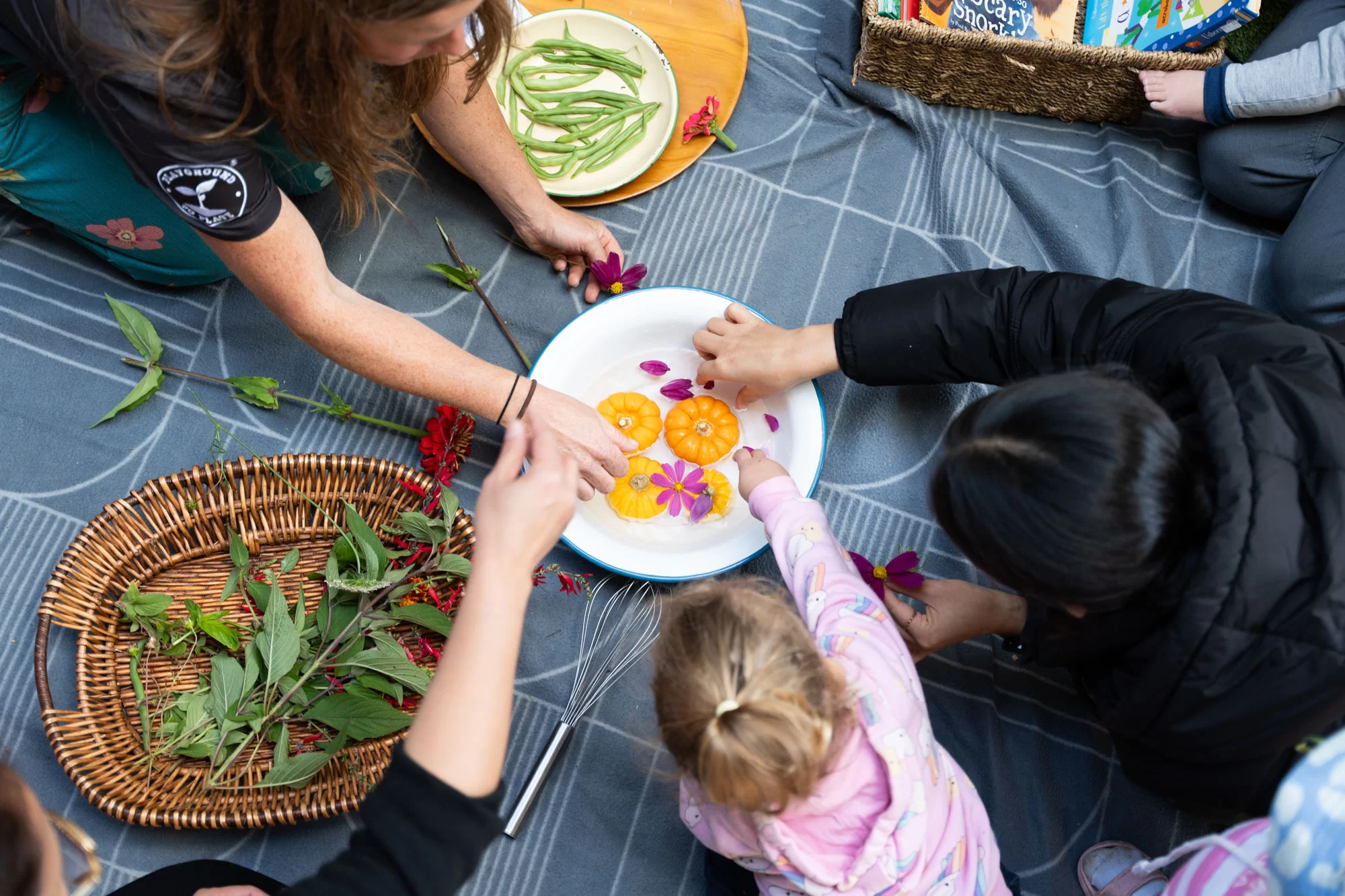 Children preparing fresh herbs and vegetables in the Playground to Plate program