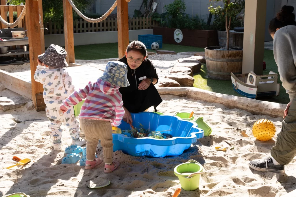 Children exploring the sandpit together at Fairfield Early Learning Centre